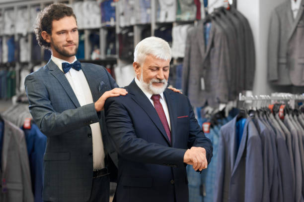 istock Senior man choosing costumes with young friend. 1302127366