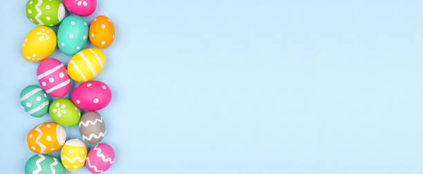 istock Colorful Easter Egg side border over a pastel blue banner background 1302127559