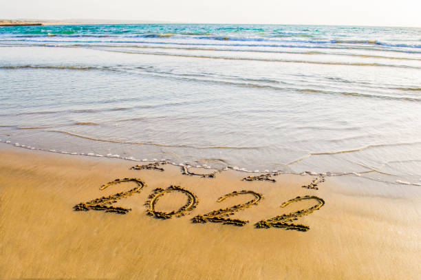 Happy New Year 2022 happy new year 2022 text on the sea beach. Abstract background photo of coming New Year 2022 and leaving year of 2021 2022 photos stock pictures, royalty-free photos & images