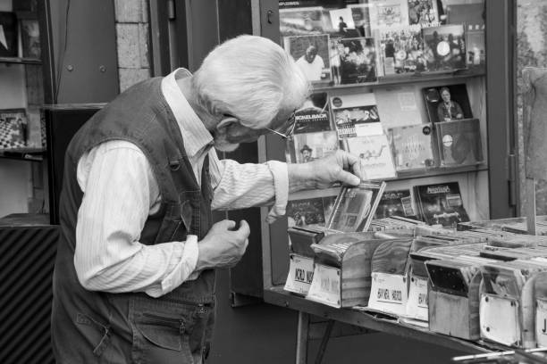 Naples, Italy - May 27, 2017. A man watching cd in an itinerant shop in the historic centre of Naples.\nNaples is the regional capital of Campania and the third-largest city of Italy, after Rome and Milan, with a population of 967,069 within the city's administrative limits as of 2017. Its province-level municipality is the third-most populous metropolitan city in Italy with a population of 3,115,320 residents, and its metropolitan area is the second-most populous metropolitan area in Italy and the 7th-most populous urban area in the European Union.