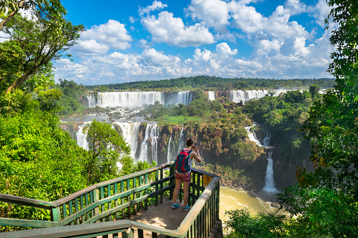 Experience the awe-inspiring beauty of Iguazu Falls, captured in this stunning photo. Located on the border of Brazil and Argentina, these iconic waterfalls are one of the natural wonders of the world, boasting breathtaking views and a powerful roar that can be heard from miles away. The cascading water and lush surrounding greenery create a mesmerizing sight that draws visitors from around the globe. This image is a must-have for anyone interested in nature, adventure, or travel, and is perfect for use in educational or tourism materials.
