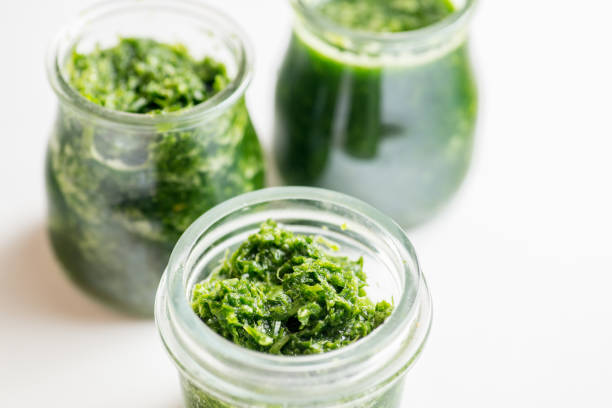 istock Pesto sauce in three jars on a white background 1302129788