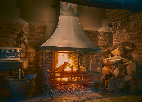 Traditional Inglenook fireplace with roaring log fire
