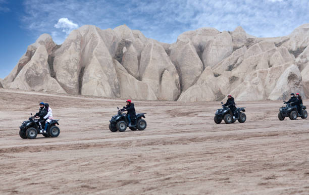 touristes appréciant une promenade de quad en cappadoce, turquie - goreme photos et images de collection