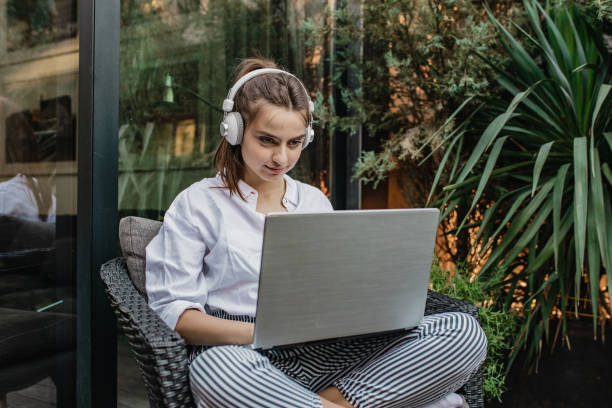 istock Young woman is using laptop at home on the balcony 1302131891