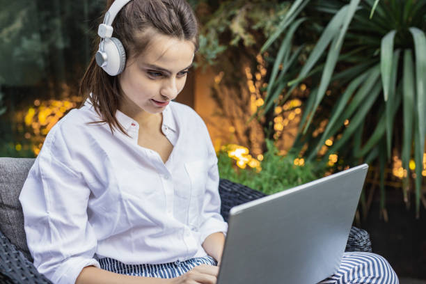 istock Young woman is using laptop at home on the balcony 1302132662
