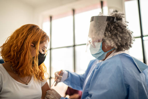 istock Young woman being vaccinated - wearing face mask 1302132773