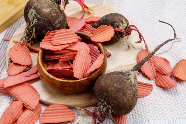 Bowl of healthy beet chips made from chickpea flour with sesame seeds on the table. healthy snack