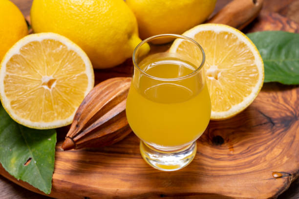 ледяной сладкий ликер лимончелло из нового урожая свежих спелых желтых итальянских лимонов, побережье амальфи, италия - neapolitan specialty стоковые фото и изображения