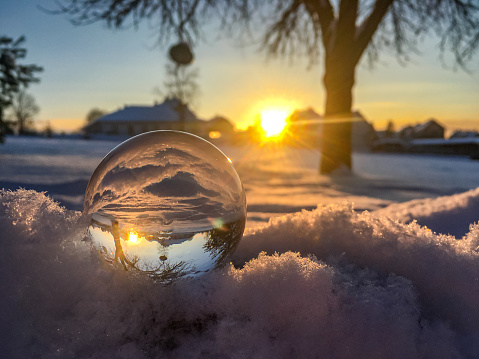 Snow globe in a winter landscape at sunset