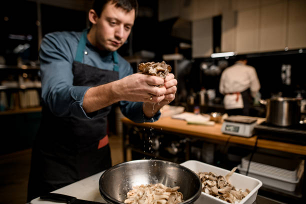 istock chef holds of oyster mushrooms over bowl on kitchen 1302140437