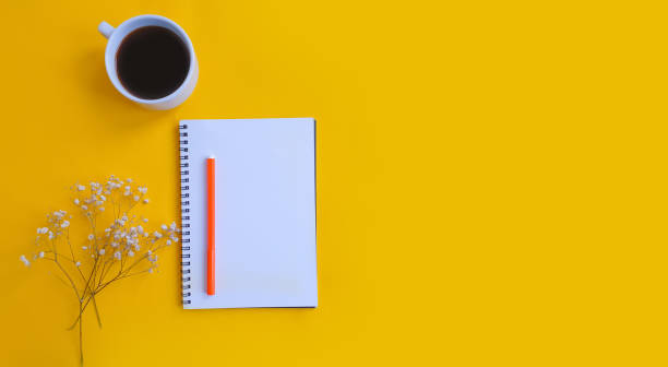 istock notebook, cup of coffee on a colored background 1302143942