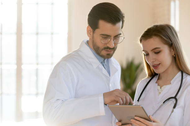 istock Two doctors male and female colleagues working on digital tablet 1302150598