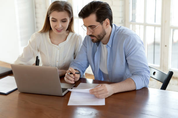 istock Man and woman coworkers comparing data working on pc together 1302150651