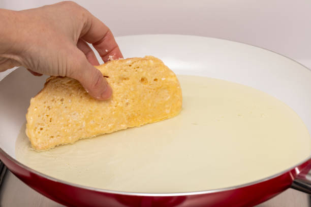 istock Woman hand and pan with oil preparing fried bread with egg and flour (Torrijas). Typical Spanish Easter sweet. Traditional home cooking concept. Horizontal photography and selective focus 1302151910