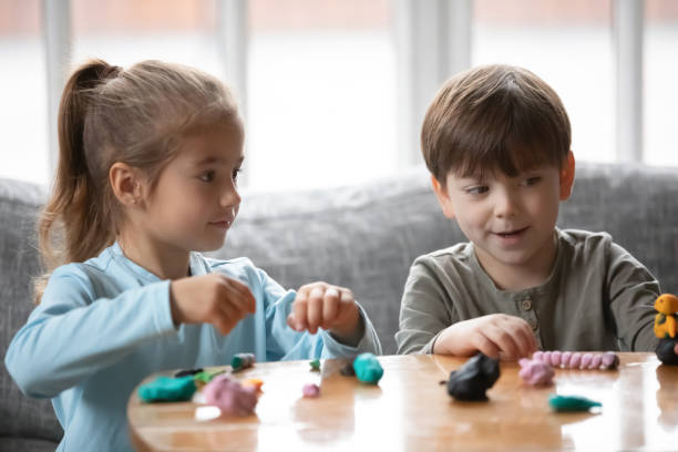 istock Joyful two cute little preschool children playing with playdough. 1302153200