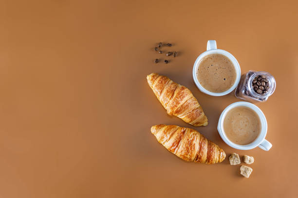 istock Cups of coffee with pastry on a brown background 1302153423