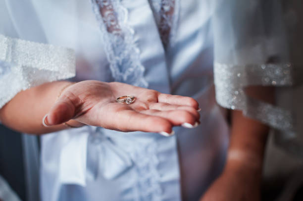 istock the bride holds a gold ring in her hands 1302154760