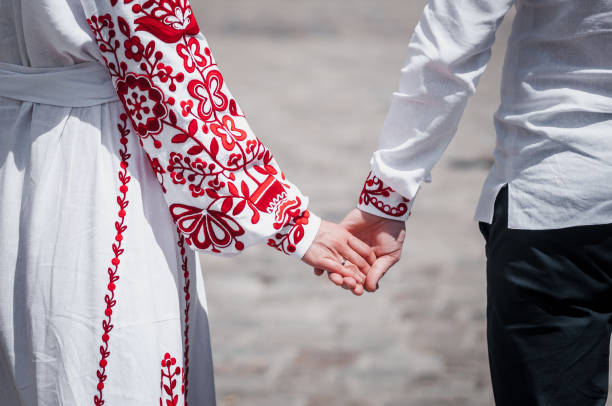 Newlyweds hold hands, dressed in red embroidery Newlyweds hold hands, dressed in red embroidery ukrainian culture stock pictures, royalty-free photos & images