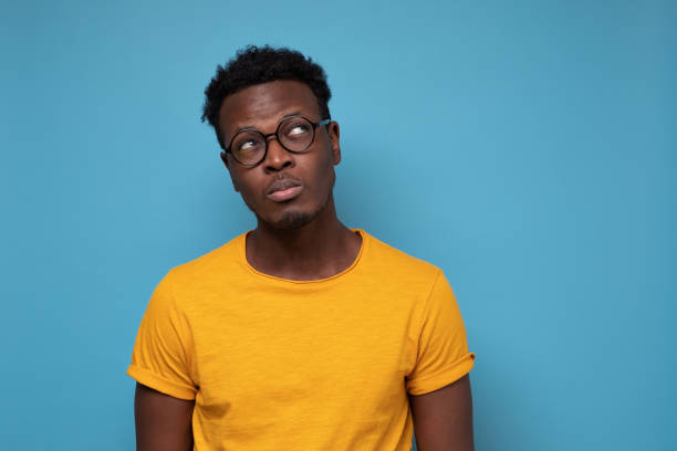 istock African man looks doubtfully aside, has hesitations, thinks what to do 1302155778