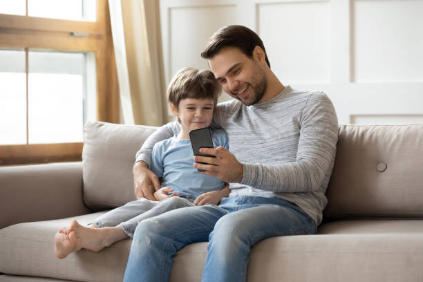istock Happy dad and small son watch video on cell 1302155972