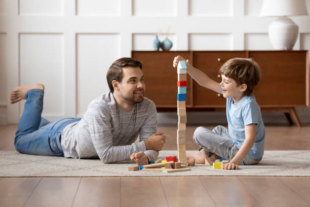 istock Happy dad and small son play with wooden blocks 1302155976