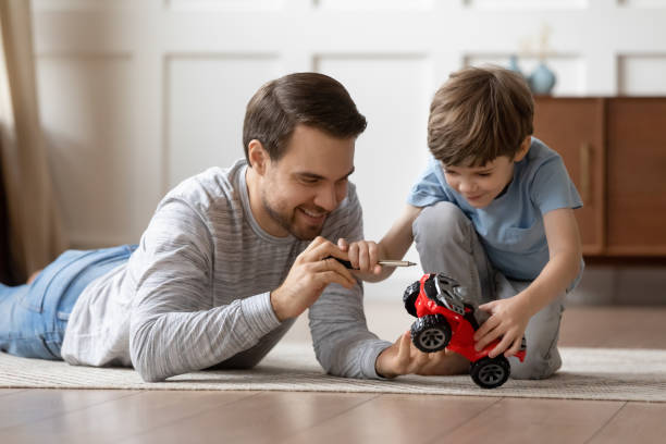 istock Happy dad play with toy car with small son 1302155980