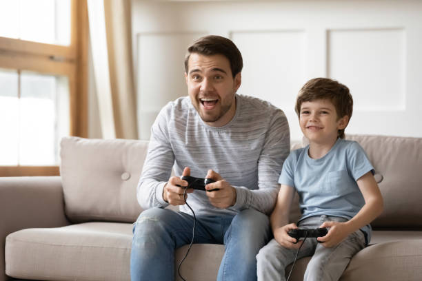 istock Happy dad and little son play video game 1302155990