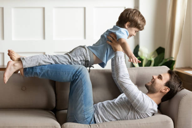 istock Loving dad play with excited little son at home 1302156027