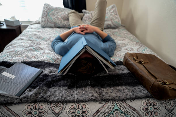 Shot of books and a pen on a bed at home
