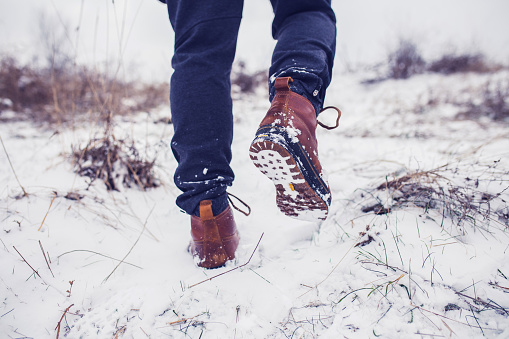 Brown men's shoes covered by snow in the winter