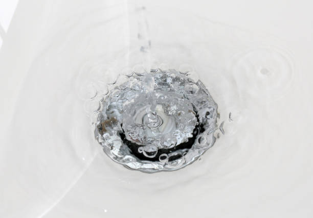 Draining water from a sink that foams in from a new clean bathroom Drainage of water from the sink that foams in the new clean bathroom low tide stock pictures, royalty-free photos & images