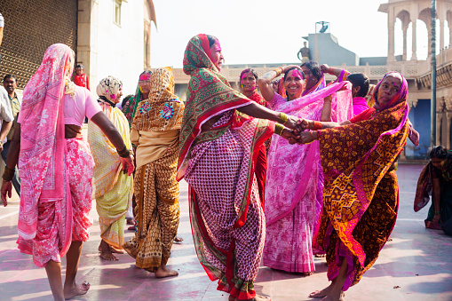 Barsana, India - March 10, 2014: Indian women dancing in colourful saris as part of the Holi festival