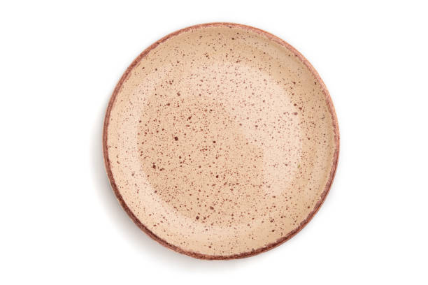 istock Empty beige dotted ceramic plate isolated on white background. Top view, close up. 1302162307
