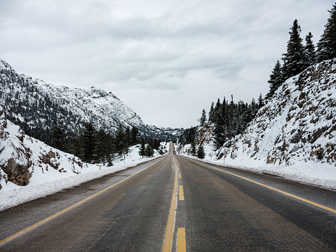 Open highway on a cloudy winter day, Forest mountains covered with snow
