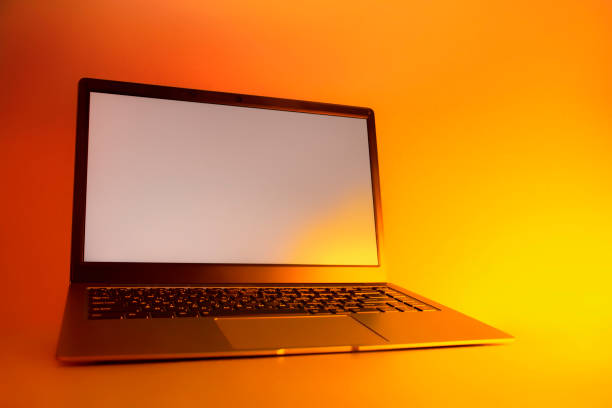istock Slim modern laptop with white screen Mockup set against bright, red creative light. 1302165096