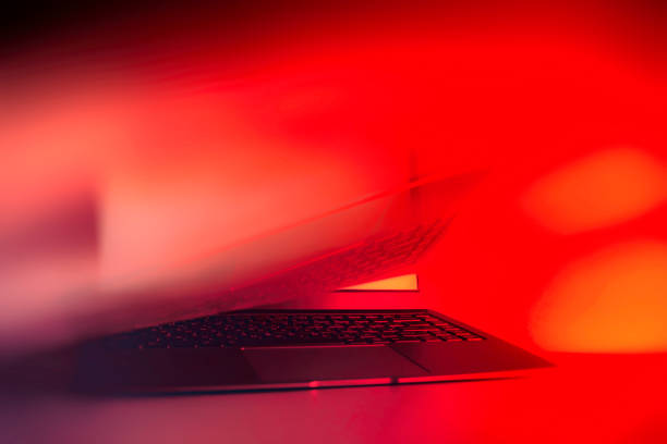istock Slim modern laptop with white screen Mockup set against bright, red creative light. 1302165097