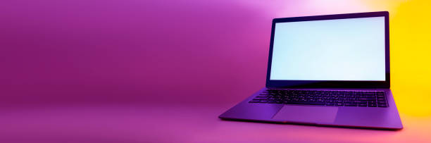 istock Slim modern laptop with white screen on the background creative light. Mockup in colorful bright neon UV blue and purple lights. 1302165102
