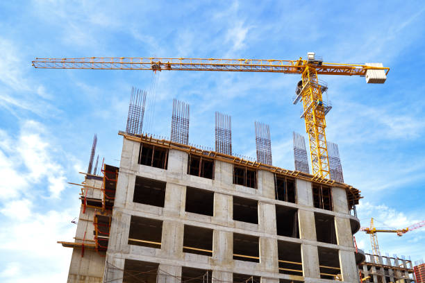 istock Construction site with buildings and cranes at blue white cloudy sky background 1302169869