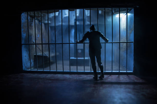 istock Jail or prison cell. Obsolete gray grunge concrete room. Creative artwork decoration. Horror view of Guillotine scale model in the dark 1302174276