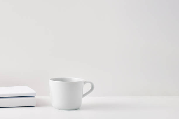 istock The mug stands on a stack of books on a white background. Natural and eco-friendly materials. Copy space, mock up 1302174703