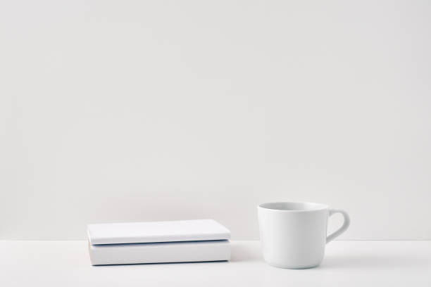 istock The mug stands on a stack of books on a white background. Natural and eco-friendly materials. Copy space, mock up 1302174705