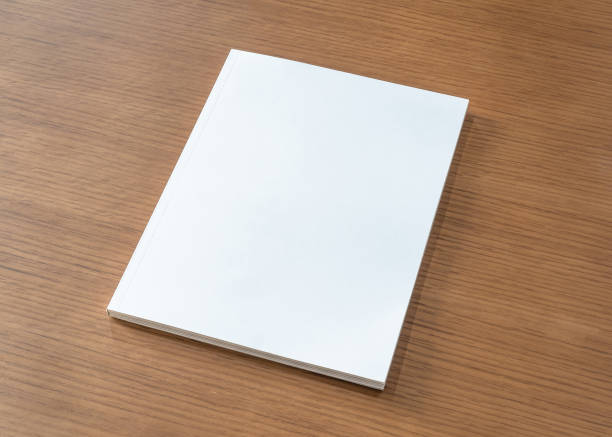 Book mockup with blank white front cover page a4 paperback mock up for catalog, magazine, menu, booklet, notebook, portfolio design template on wood table background Book mockup with blank white front cover page a4 paperback mock up for catalog, magazine, menu, booklet, notebook, portfolio design template on wood table background a4 paper stock pictures, royalty-free photos & images