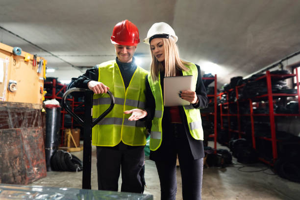 istock Worker and warehouse manager sorting finished rubber mats for the gym in a warehouse by using a digital tablet and pallet jack 1302175056