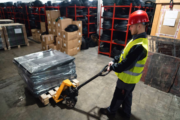 istock One warehouse worker with hand pallet jack unloading pallet goods in a warehouse 1302175067
