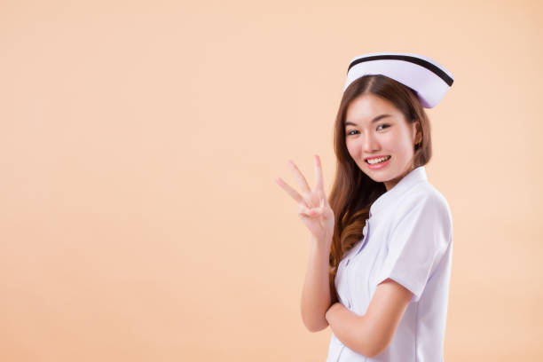istock asian nurse pointing three fingers up 1302175990