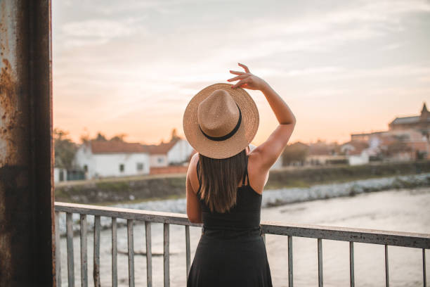 istock Woman tourist with hat watching sunset 1302176097
