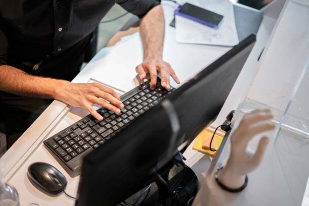 istock A clothing store clerk writes down sales data on his computer 1302177301