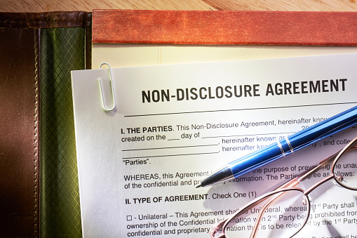 Non-Disclosure Agreement. Confidentiality Agreement on note pad, with glasses and pen