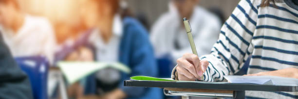 istock Exam at school with student's taking educational admission test in class, thinking hard, writing answer in university classroom, education and world literacy day concept 1302185609